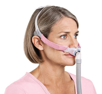 ResMed Swift FX For Her nasal pillow CPAP mask worn on a person's head.