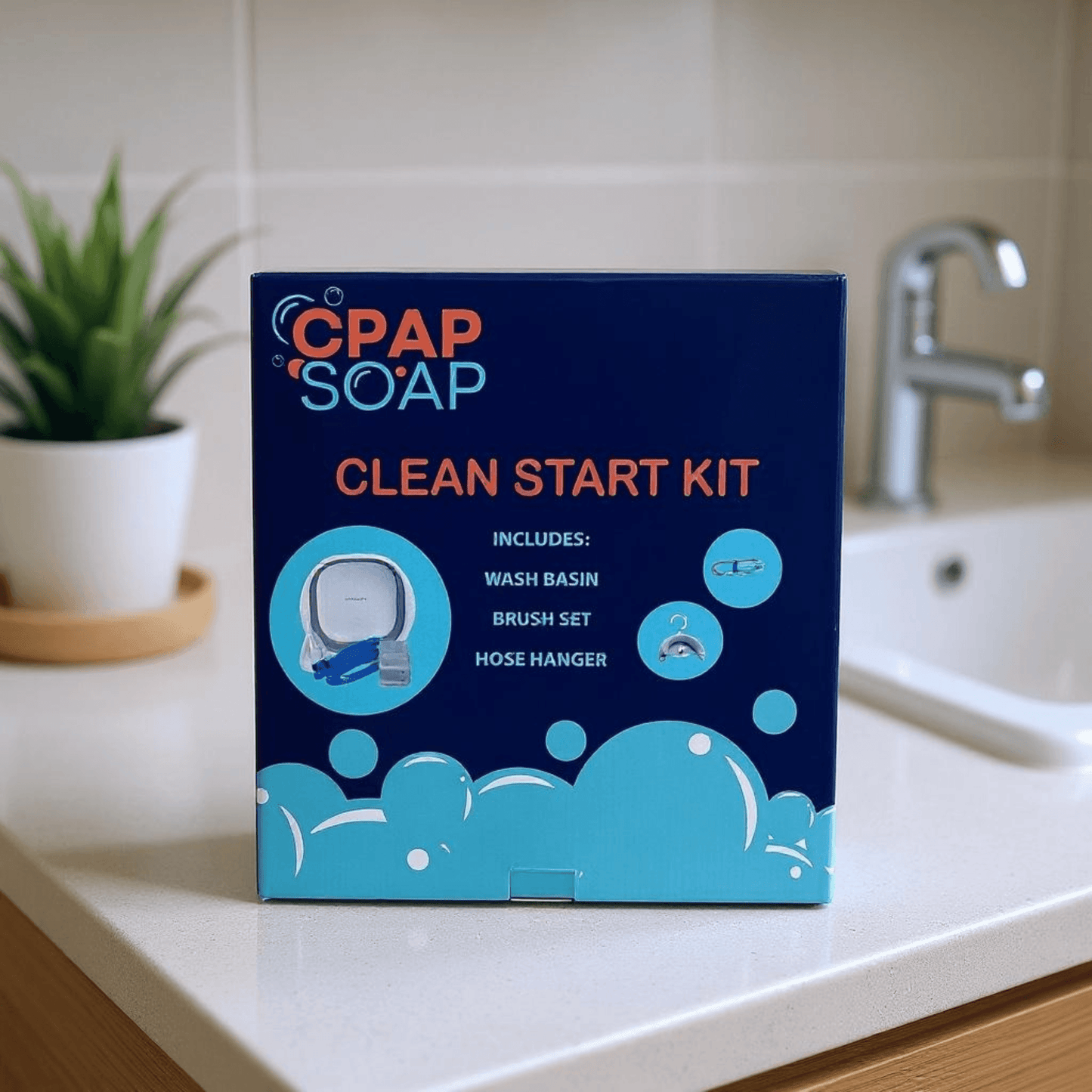 CPAP Soap Clean Start Kit product box on a bathroom countertop listing included items: wash basin, brush set, and hose hanger