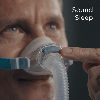 Close-up of a man wearing the Fisher & Paykel Nova Nasal Mask, with a finger pointing to the front-mounted diffuser. Text overlay reads "Sound Sleep," highlighting the whisper-quiet operation.