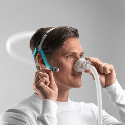 A male user adjusting the Fisher & Paykel Nova Nasal Mask, demonstrating the flexibility and easy adjustment of the SwingFit headgear design.