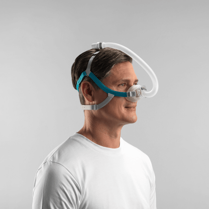 Profile view of a male user sleeping comfortably with the Fisher & Paykel Nova Nasal Mask, demonstrating how the Tube Clip routes the hose over the head to keep it out of the way.