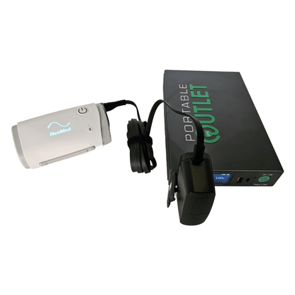 A ResMed AirMini travel CPAP machine powered by the Portable Outlet X9 battery, showing the standard power block plugged directly into the battery without needing extra adapters.
