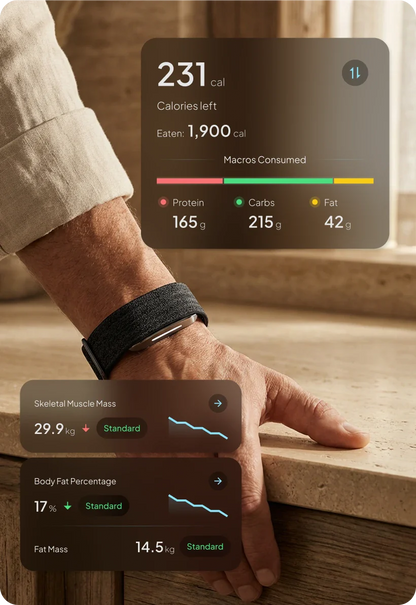 Hand wearing a hume 2 smartwatch with fitness and health data displayed on a wooden surface