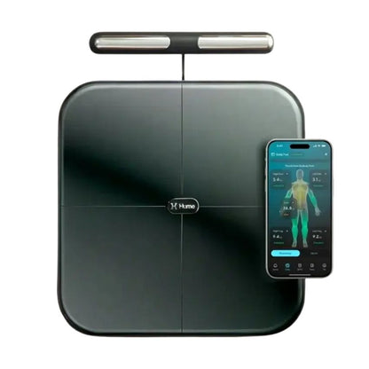 A Hume smart body scale in dark gray with a sleek top bar, shown alongside a smartphone displaying its companion app on a white background.