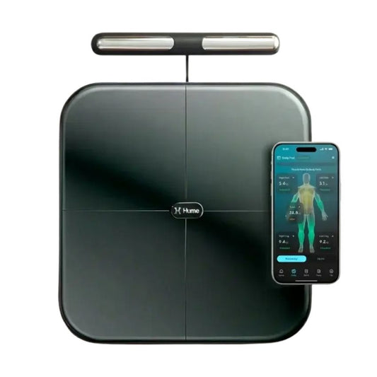 A Hume smart body scale in dark gray with a sleek top bar, shown alongside a smartphone displaying its companion app on a white background.
