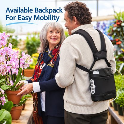 A man wearing a black backpack with the liberty 2 portable oxygen concentrator and cannula in a garden center, standing next to a woman holding potted pink flowers. Blue text in the top left reads 'Available Backpack For Easy Mobility'.
