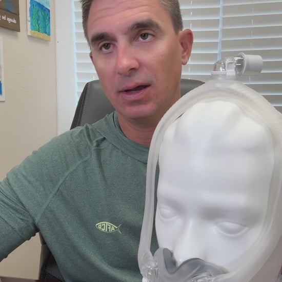 A feature showcase of the ResMed AirTouch F30i full face CPAP mask. The video highlights the hybrid ComfiSoft cushion with a fabric-fused seal, the hollow frame design for top-of-head hose connection, and the QuietAir venting technology. It demonstrates the mask's clear frame and under-the-nose fit that leaves the bridge of the nose free and provides an open field of vision.