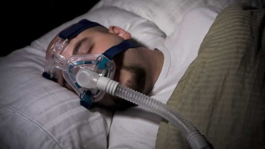 Sleeping man wearing CPAP mask